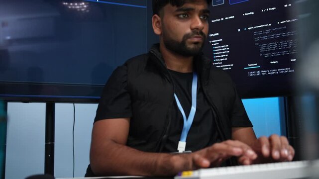 Bearded coder debugs code on multiple screens