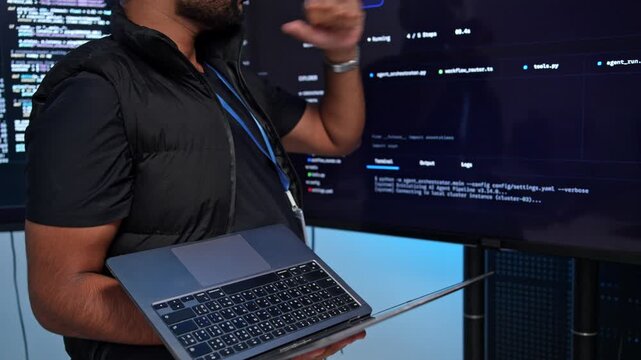 Coder typing code on glowing screen in dark tech lab