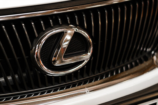 Krakow, Polska - September 06, 2026: Lexus emblem on chrome grille with black vertical slats and white bodywork, detailed automotive brand close up