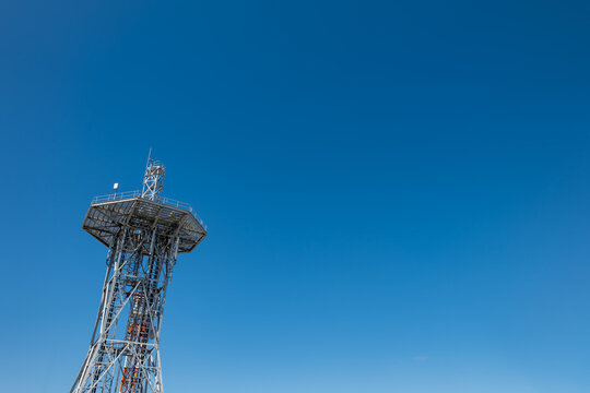 青空を背景にそびえ立つ鉄塔、通信インフラの風景
