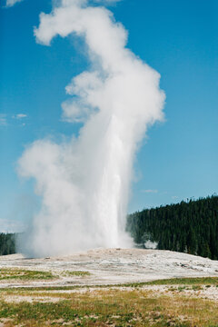 Old Faithful geyser erupting high into the sky