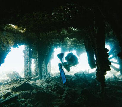 Scuba diver explores the inside of a sunken shipwreck