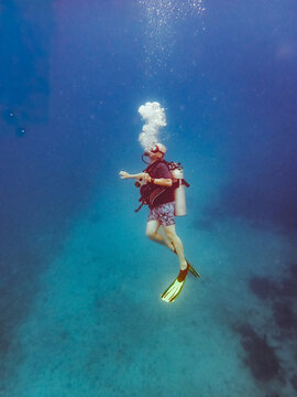 Male scuba diver explores the deep blue sea