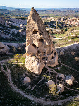 Aerial view of Uchisar Castle, a historic rock-cut fortress carved into volcanic tuff, surrounded by the unique landscape of Cappadocia in Uchisar, Nevsehir, Turkiye.