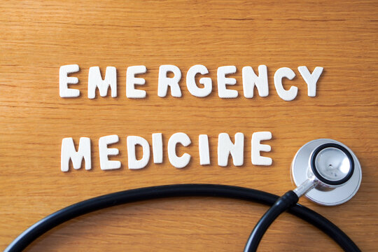 the words emergency medicine formed with wooden letters, accompanied by a black medical stethoscope.