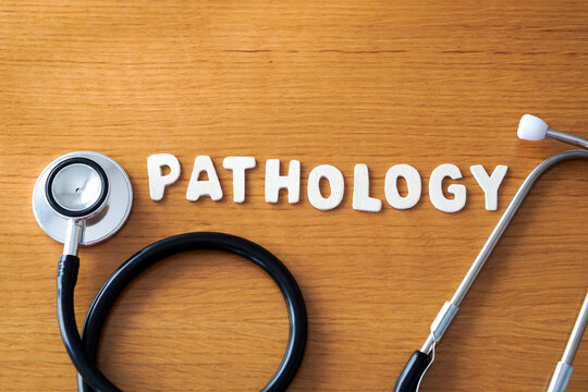 The word pathology formed with wooden letters, accompanied by a black medical stethoscope.