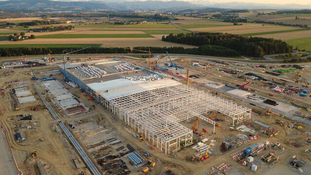 Aerial view of a data center construction site with steel framework, cranes, and heavy machinery in the countryside of Kronstorf, Upper Austria, Austria.