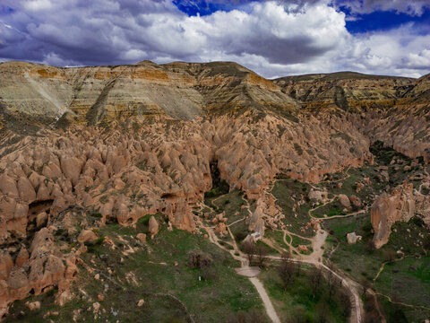Aerial view of Zelve Vadisi with its unique fairy chimneys, rock-cut dwellings, and winding paths through the rugged volcanic landscape in Goreme, Nevsehir, Turkiye.
