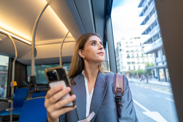Young woman commuting on public bus looking out window © unai