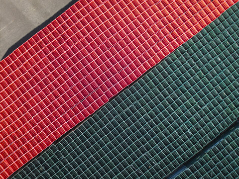 Aerial view of red and green plastic crates arranged in a grid pattern in Poland.