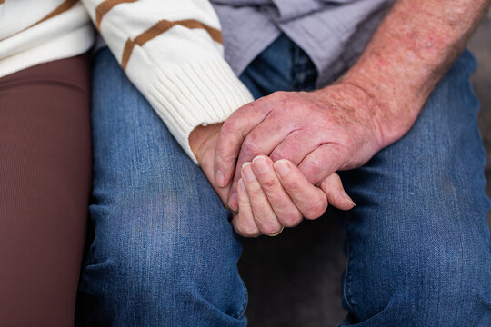 hands of an older couple clasped together showing a loving relationship
