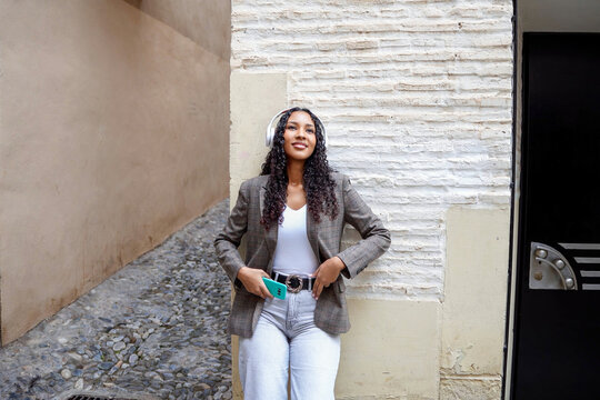 Chic woman with hands on hips radiates style and selfassurance in city environment
