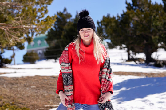 Tranquil woman sporting layered winter garments stands confidently on snowcovered path