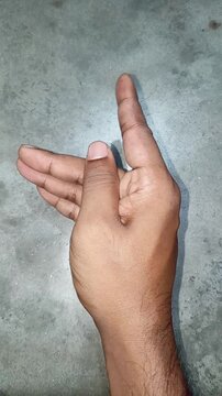Close up of a male hand making a beckoning gesture with the index finger to summon or invite