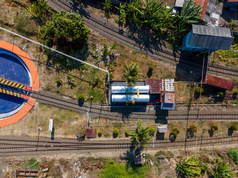 Aerial view of a railway turntable and storage tanks located near train tracks in Cilacap, Central Java, Indonesia.