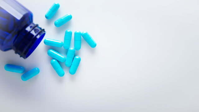 Health care background of pills and bottle on white surface flat lay