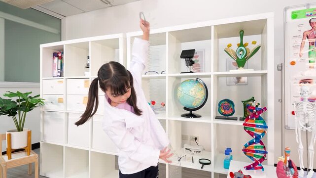 Young Girl in Lab Coat Playing with Slinky Spring in Classroom