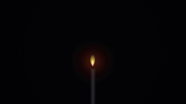 A single burning candle radiates a soft glowing flame within the deep darkness of the night, providing a sense of spiritual hope and peaceful meditation for those who seek solace in quiet