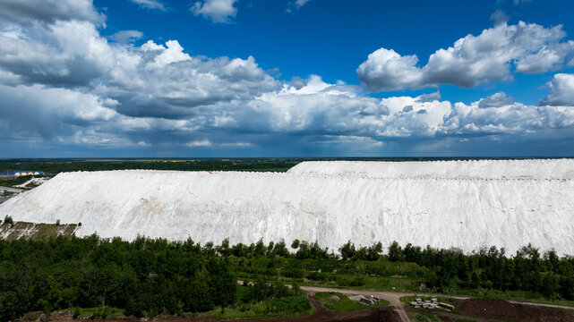 Huge white industrial hills under dramatic summer clouds in Lithuania