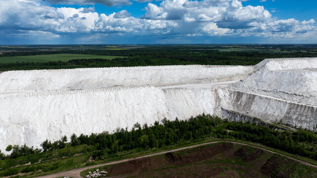 Huge white industrial hills under dramatic summer clouds in Lithuania