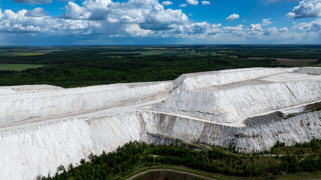 Huge white industrial hills under dramatic summer clouds in Lithuania