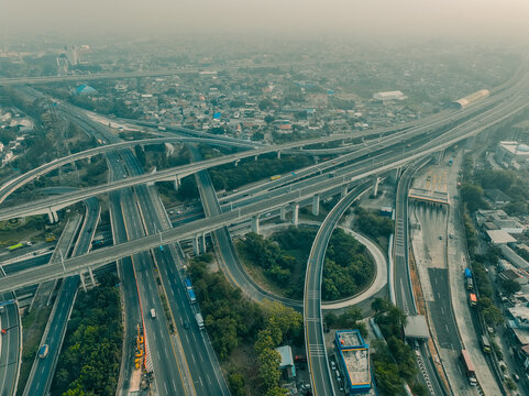 Aerial view of the Cikunir interchange, a complex multi-level highway junction with elevated roads and surrounding urban development in Kecamatan Bekasi Selatan, Jawa Barat, Indonesia.