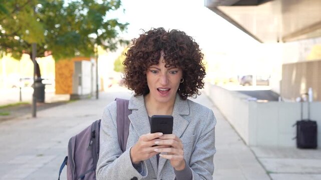 A modern woman is seen texting on her smartphone while enjoying the outdoors in the city