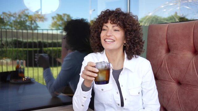 Smiling Woman with Curly Hair in Caf Setting