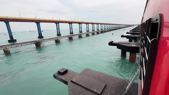 Wide Angle POV View from Moving Indian Train Crossing Pamban Bridge over Ocean. Side Angle View of Red Indian Railway Coach Moving Along Indian Ocean Over Indian railway Bridge.