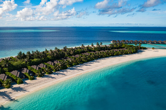 Stunning aerial tropical island turquoise lagoon white sand beach lush palm forest coral reef paradise above. Peaceful summer nature seascape scene. Luxury drone travel scenic coastal getaway view