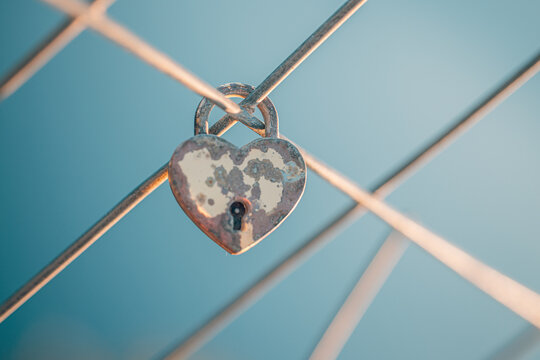 Romantic love padlock heart shaped lock soft pink bokeh fence symbol eternal devotion couples valentine commitment. Conceptual romance emotion scene. Wedding anniversary bond memory hope pledge