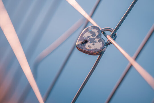 Romantic love padlock heart shaped lock metal fence blue sky symbol eternal devotion couples valentine commitment. Conceptual romance emotion scene. Wedding anniversary bond memory hope pledge