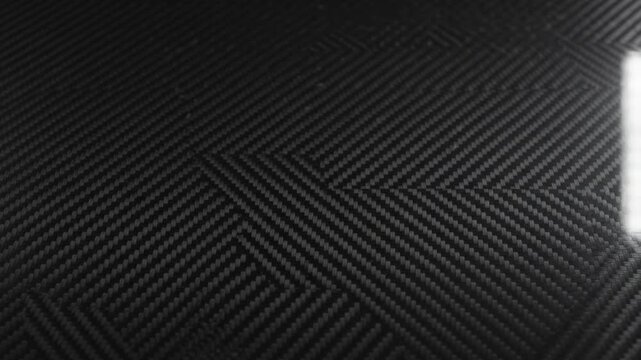 Abstract Dark Carbon Fiber Woven Texture Background with Light Sweep