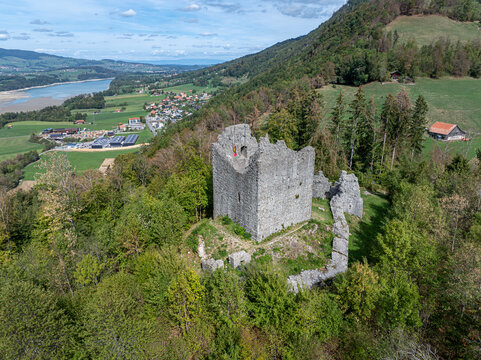 Aerial view of the ruins of Burg Montsalvens surrounded by lush green forests and rolling hills in Broc, Fribourg, Switzerland.