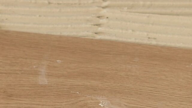 Professional floor layer installing wooden parquet flooring