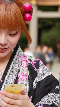 Japanese Women in Traditional Kimono Reading Omikuji Fortune at Meiji Shrine