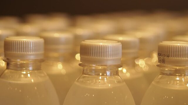 Rows of refreshing beverage bottles lined up in perfect formation with soft focus lighting.