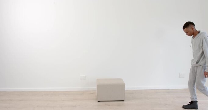 High speed photography for dynamic scenes, Man in gray tracksuit standing indoors, looking at.