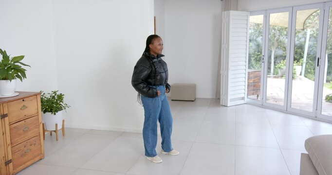 High speed photography for dynamic scenes, standing with arms crossed, woman smiling in modern livin