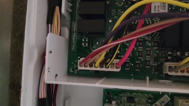 Close up of a circuit board and colored network cables inside electronic equipment