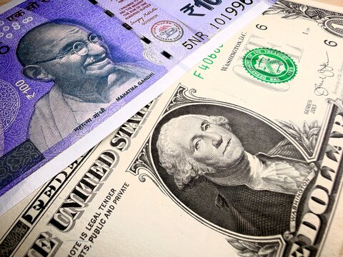 US one dollar bill and Indian hundred rupee note George Washington and Mahatma Gandhi close up photo