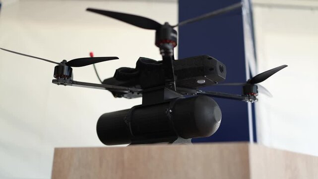 FPV military drone equipped with a combat munition for aerial dropping showing how compact unmanned aircraft can carry payloads during modern tactical combat operations