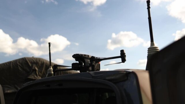 Remote weapon station mounted on a military vehicle with targeting equipment and antennas showing modern defense technology and tactical surveillance systems outdoors now