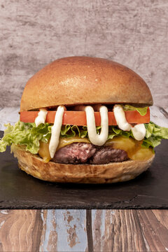 Classic Cheeseburger with Lettuce, Tomato, and Mayo Drizzle on Slate