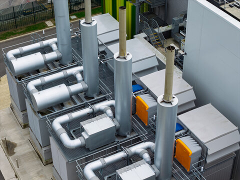 Aerial view of the industrial cooling and ventilation system on the roof of a data center with metallic pipes and exhaust stacks in the United Kingdom.