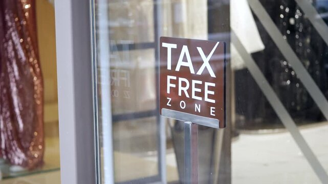 Tax free zone sign on glass door, concept of retail shopping and duty-free purchases.