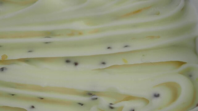 Creamy soft serve ice cream texture with swirls and speckles.