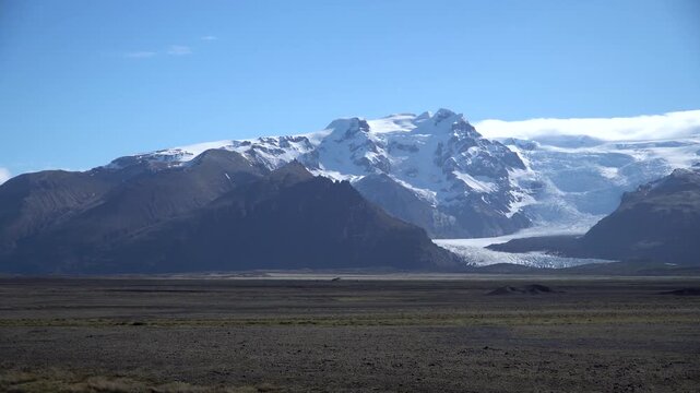 Oraefajokull outlet glaciers and Hvannadalshnukur, the highest mountain in Iceland, seen across the flat sandur plain.