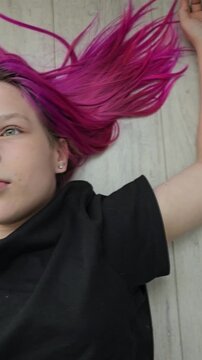 Portrait of a sad teenage girl lying on the floor. Stress, depression, relaxation, mental health