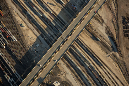 Aerial view of a highway overpass crossing a vast rail yard with numerous freight trains and tracks in Kansas City, Missouri, United States.